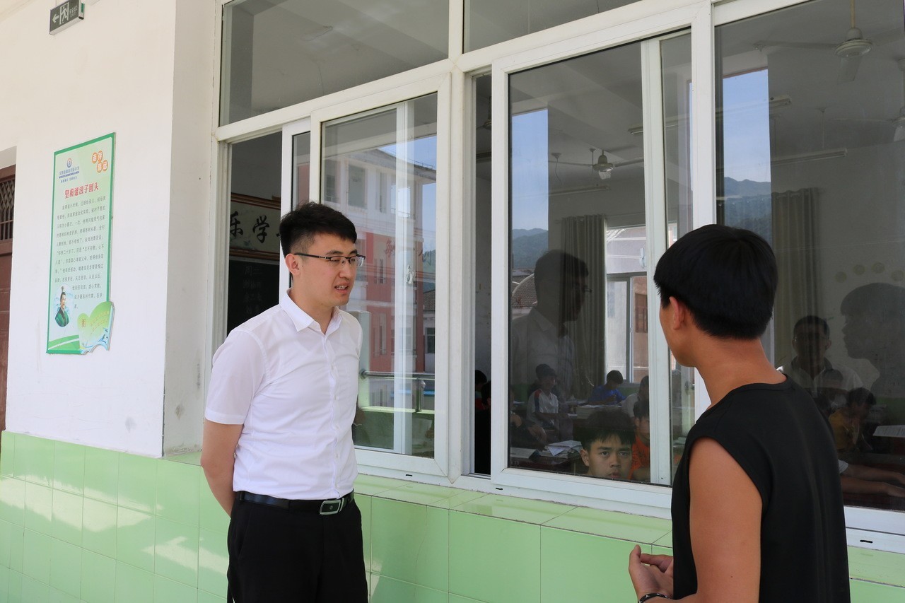 孔德帅查看九年级教学情况，向九（6）班学生石林核实本班学生人数。杨登武 摄.jpg